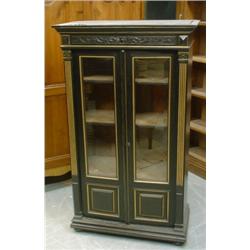 Une vitrine victorienne en bois noirci partiellement dorée, la corniche moulurée au-dessus d'un b...