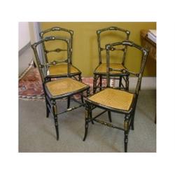 Un ensemble de quatre chaises victoriennes en bois noirci à décor incrusté de nacre et peint de r...