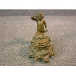 Un encrier en bronze patiné, la base en forme de plume et de griffe d'aigle supportant un encrier...