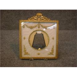 Un encadrement de photo en métal doré à décor fleuri....