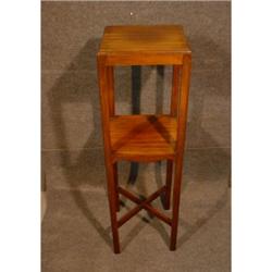 Un guéridon carré à 2 étages en acajou sur des pieds droits réunis par une entretoise en "x"....