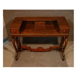 Un bureau en palissandre, le plateau surmonté de trois tiroirs sur des montants découpés en forme...