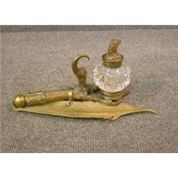 Un encrier en bronze patiné orné d'un chérubin forgeant un coeur, (petit dommage)....