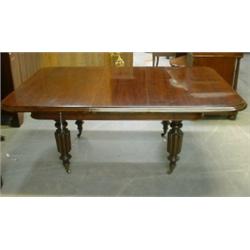 Une table de salle à manger victorienne en acajou, le plateau rectangulaire arrondi sur des pieds...