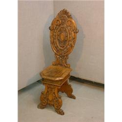 Une escabelle de style Renaissance en noyer, le dossier ovale sculpté d'un écusson et de feuillag...