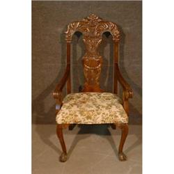 Une chaise d'entrée en acajou de style Chippendale, le dossier sculpté d'une urne fleurie et d'un...