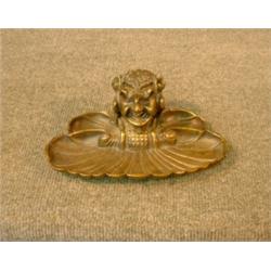 Un encrier en bronze patiné orné d'un personnage grotesque....