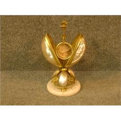 Un porte-montre en nacre à décor de laiton doré....