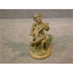 Un porte-allumettes en métal doré en forme de joueur de banjo....