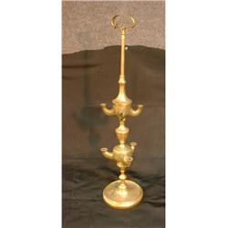 Une lampe à huile en laiton gravé.  A chased brass oil lamp. $125/175...