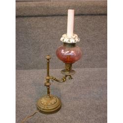 Une lampe à huile ajustable en verre pourpre sur une base en métal doré....