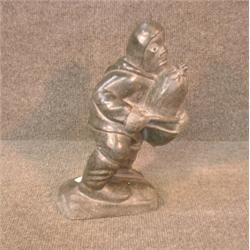 Une sculpture inuit en stéatite représentant un homme portant un sac, signé....