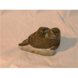 Une sculpture inuit en stéatite représentant un phoque, signée: "Arpilie Sala"....