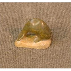 Une sculpture inuit en stéatite représentant une baleine, signée....