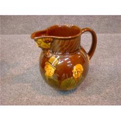 Un broc à eau en porcelaine "Kingsware" de Royal Doulton, le bec verseur à décor moulé de la tête...