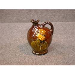 Un broc en porcelaine Kingsware de Royal Doulton: "Micawber, the Ever-Expectant", vers 1937....