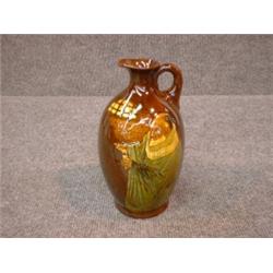 Un broc en porcelaine "Kingsware" de Royal Doulton décoré d'un alchimiste, signé: "J. Cox", vers...