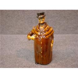 Une bouteille en porcelaine "Kingsware" de Royal Doulton en forme de cocher, la tête amovible, ve...