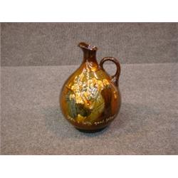 Un broc en porcelaine "Kingsware" de Royal Doulton: "He's a jolly good fellow", vers 1923....