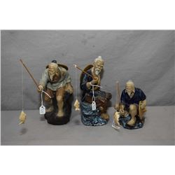 Three large mud men figures including 8" standing with fish on line, and two men sat fishing