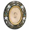 Image 1 : A Derbyshire black marble and stone inlay oval frame, decorated border of white lilies and laurel...