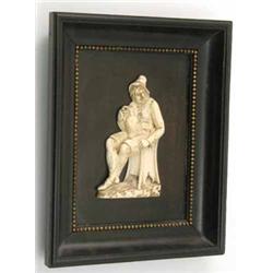 A 19th century carved Dieppe ivory relief of a seated gentleman, modelled holding a flagon and se...