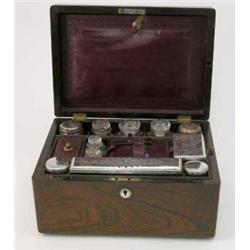 An Edwardian rosewood toilet box, with compartmented interior housing six toilet jars and boxes w...
