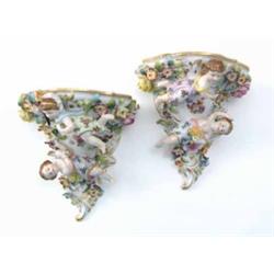 A pair of 19th century Dresden wall brackets, modelled with clothed nymphs and encrusted with flo...