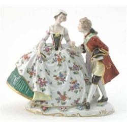 A Naples porcelain figure group, female in voluminous evening dress painted with fruit, male comp...
