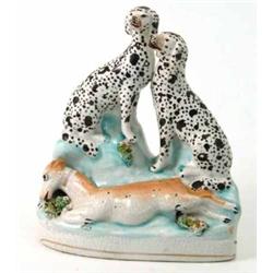 A Victorian Staffordshire dalmatian group, two dalmatians seated overlooking an injured dog, 7in....