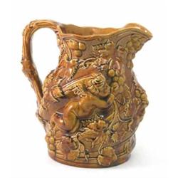 A Mintons earthenware Bacchus jug, glazed in brown monochrome and relief-moulded with cherubs, gr...