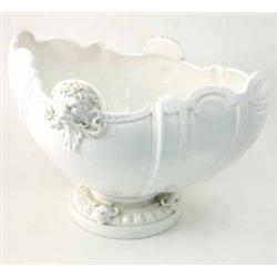 A large white-glazed earthenware jardiniere, of lobed oval form moulded with lion-mask handles, o...