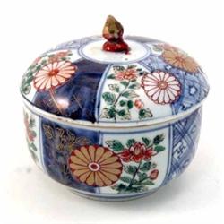 A 19th century Imari bowl and cover, painted with peonies and other flowers in traditional colour...