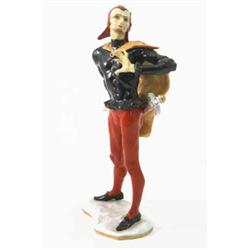 A German porcelain figure of an actor, wearing head-dress, cape, a broadsword attached to belt, 9...