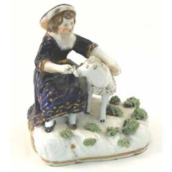 An early Victorian Staffordshire bone china figure, lady seated with lamb, on cushion base, 4.5in...