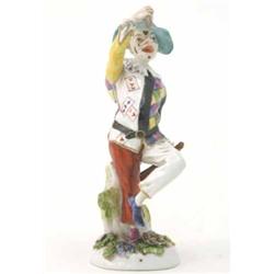 An old English harlequin figure, wearing chequered jacket, dancing with arm aloft, on circular ba...