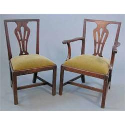 A set of seven George III mahogany dining chairs, including one with arms, with pierced splats an...