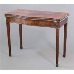 A George III mahogany serpentine card table, with oval floral paterae above the reeded square tap...