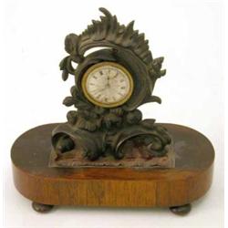 A Regency bronze mantel timepiece, with asymmetrical scroll case and verge movement, rosewood pli...