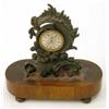 Image 1 : A Regency bronze mantel timepiece, with asymmetrical scroll case and verge movement, rosewood pli...