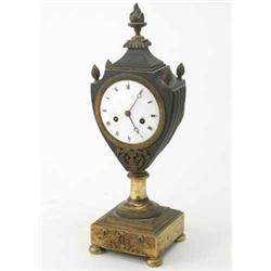 An early 19th century French bronze and ormolu mantel clock, in urn shaped case with enamelled Ro...