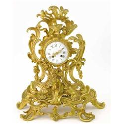 A 19th century French ormolu mantel clock, with asymmetrical rococo scroll case and enamelled Rom...
