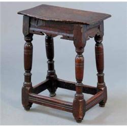 A 17th century oak joynt stool, with damaged seat, shaped aprons and turned legs, 1ft 6ins...