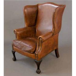 A George III design wing back armchair, upholstered tan leather on cabriole legs with claw and ba...