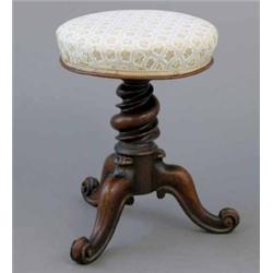 A Victorian walnut revolving piano stool, on spiral column and tripod...