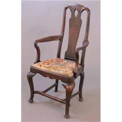 An early 18th century walnut elbow chair, with vase splat back and shepherd's crook arms, on cabr...