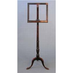 An early 19th century mahogany music stand, on turned stem and tripod...