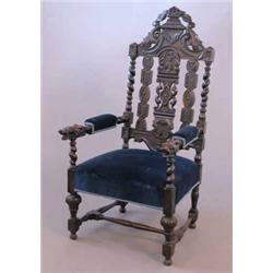 A Victorian carved oak elbow chair, the arms terminating in carved dog's heads...