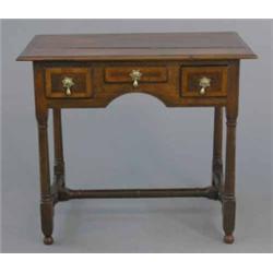 A mid 18th century oak lowboy, with three drawers on turned legs with cross stretcher, (split top...