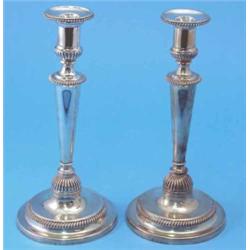 A pair of George III silver candlesticks, with gadrooned and fluted decoration, each capital supp...